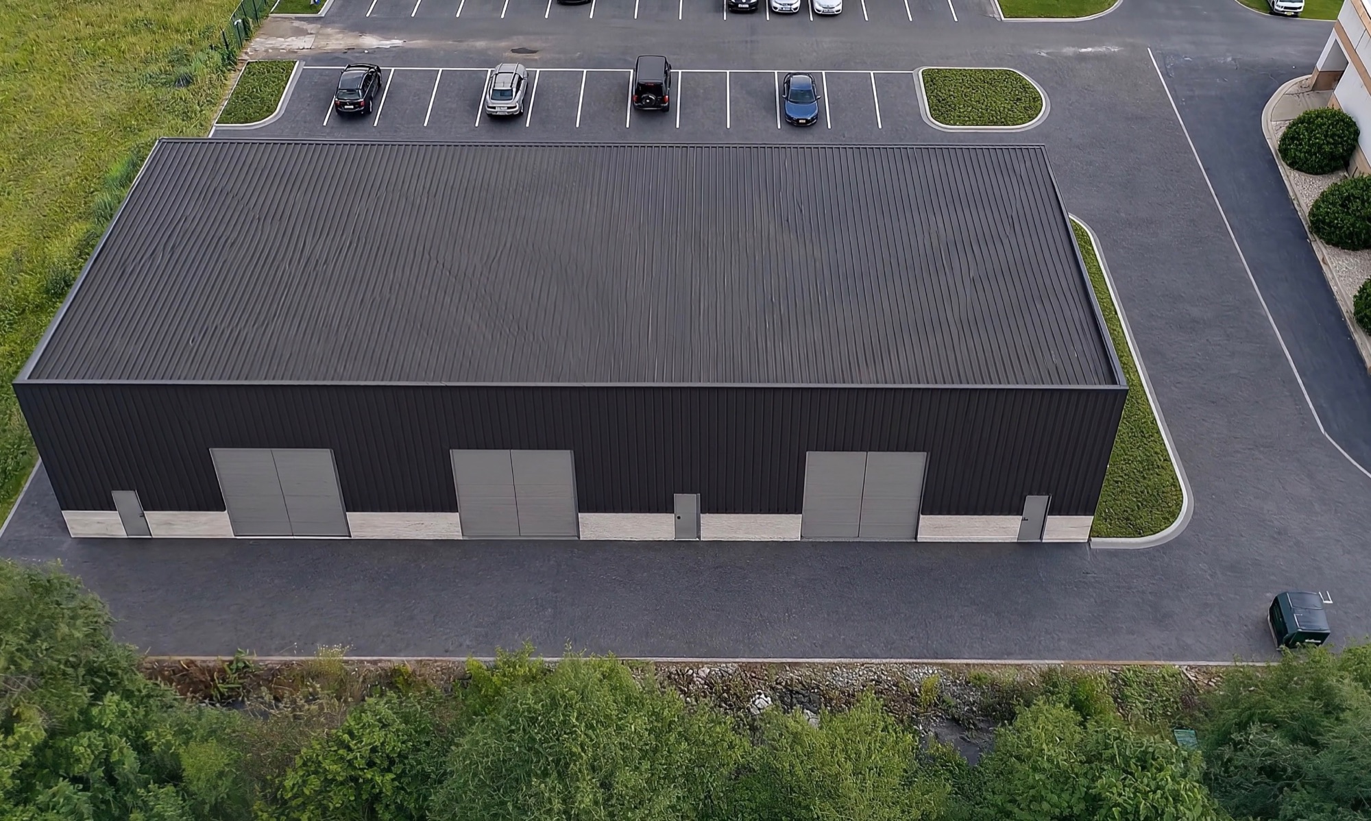 Rear elevation showing three overhead doors and paved loading area